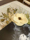 Detailed view of preserved white wedding flowers, leaves and delicate stems inside a Held in Bloom pressed flower frame.