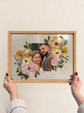 Oak Held in Bloom pressed flower frame held up against a cream wall, featuring a wedding photo surrounded by preserved bridal bouquet flowers.
