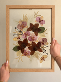 Preserved flowers being selected and arranged during the Just Bloom pressed flower frame design process.