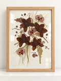 Front view of a Just Bloom pressed flower frame featuring preserved burgundy and striped pink orchids.